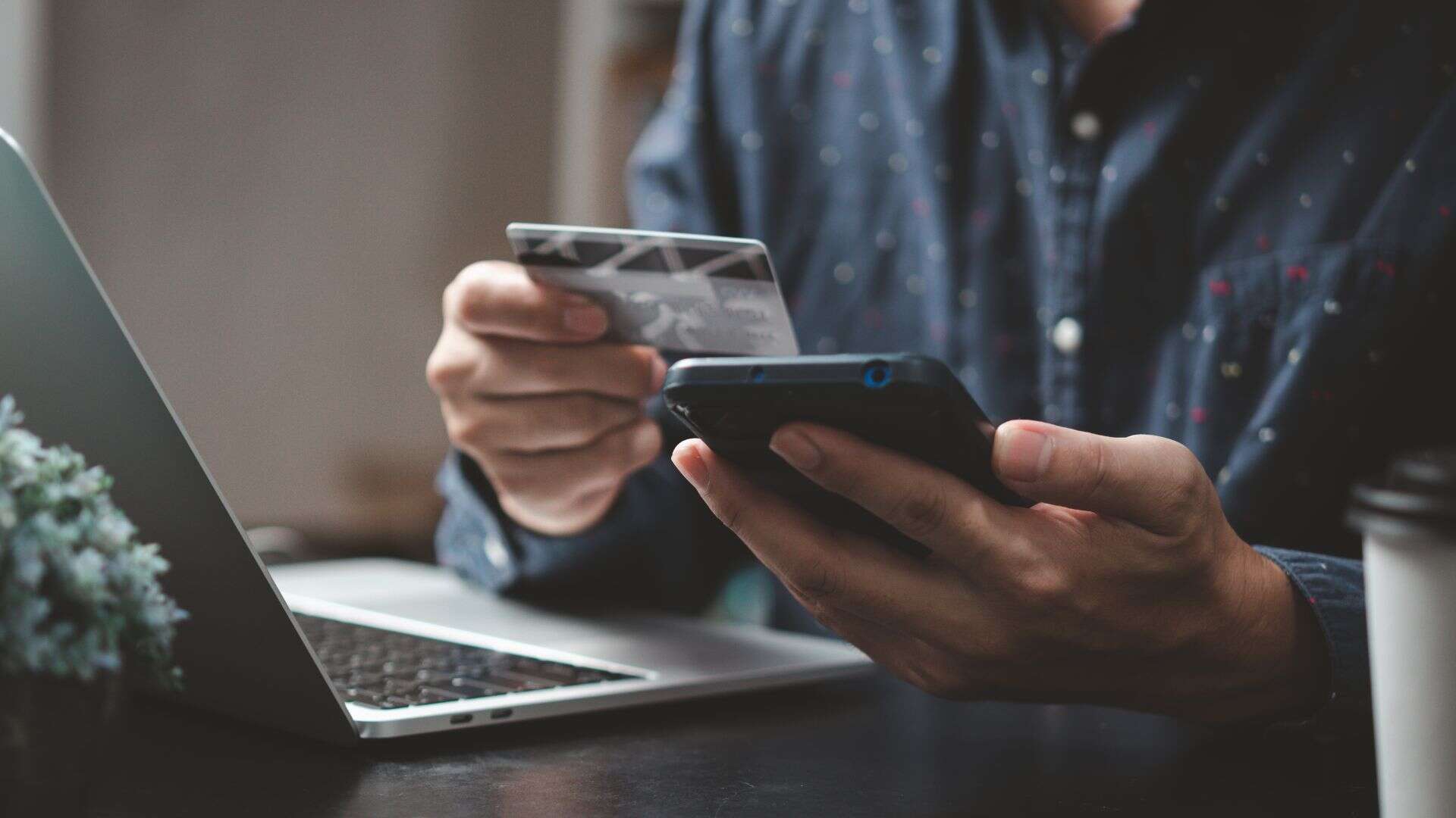Un uomo al pc paga i costi del servizio di airbnb