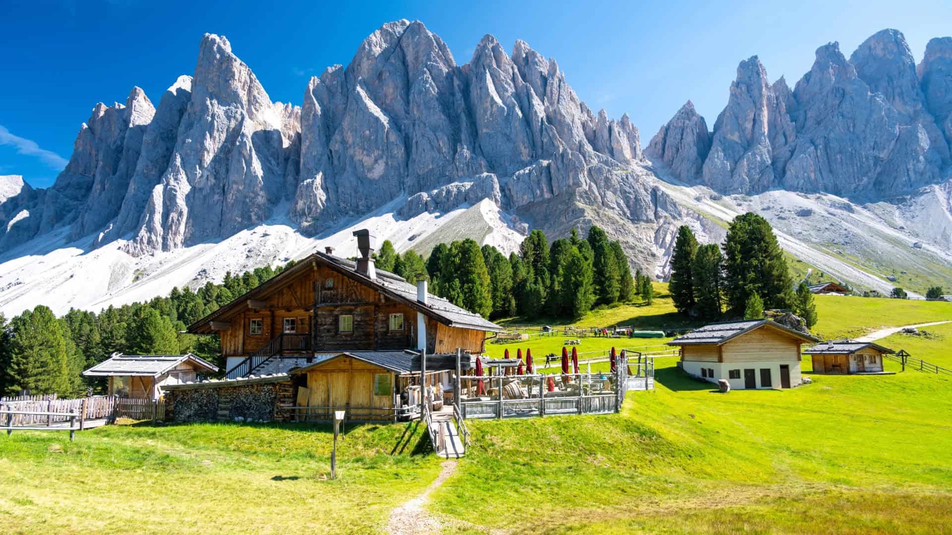 Un rifugio con alle spalle le montagne della Val di Funes
