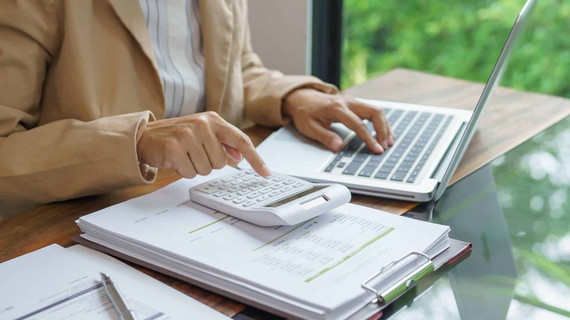 Donna calcola al pc la percentuale di commissione di booking