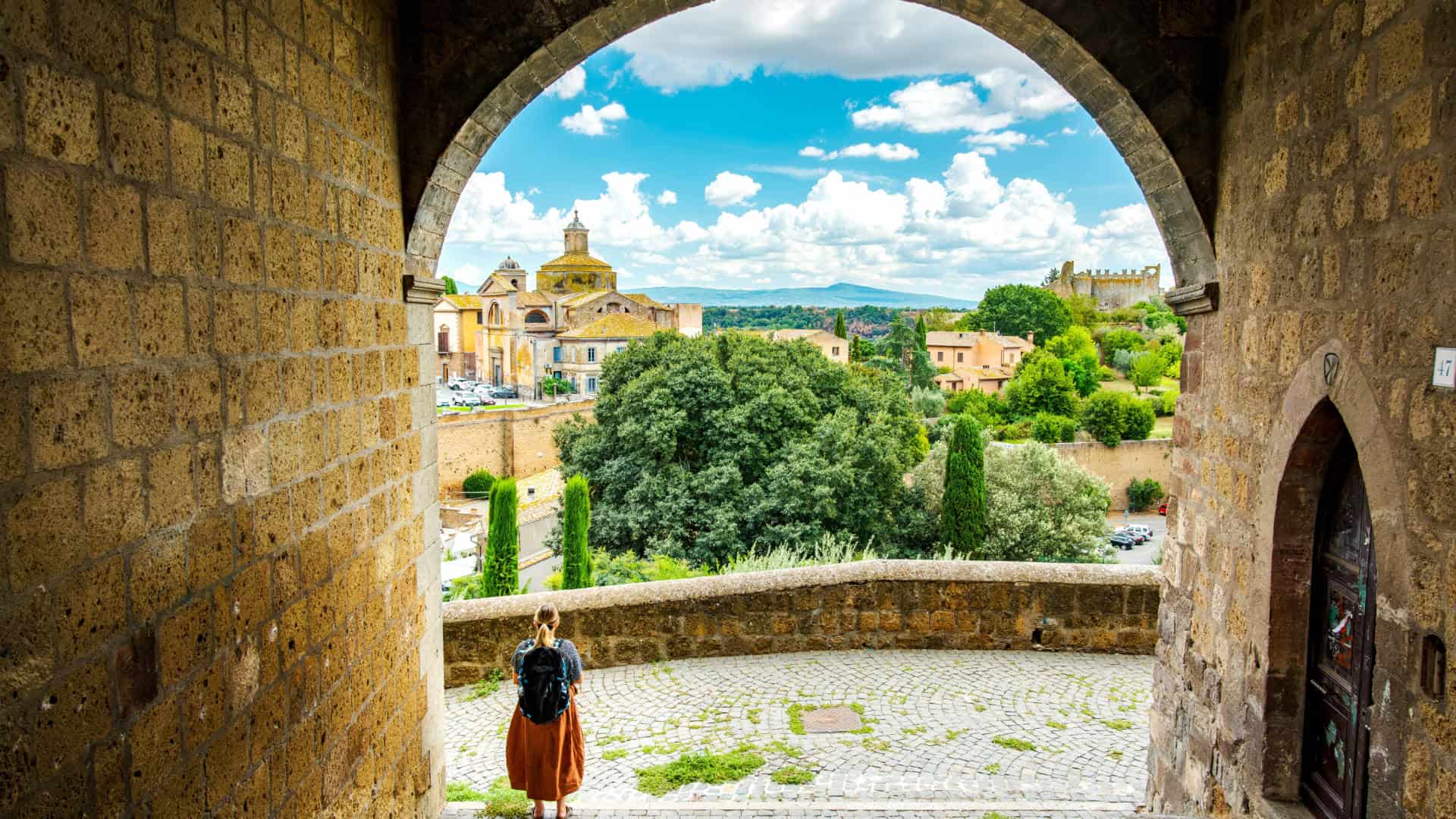 Scorcio su Viterbo con una donna che cammina sotto un arco